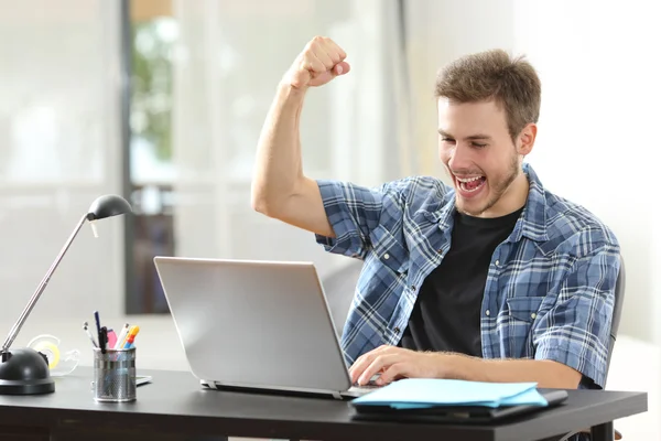 Homem vencedor eufórico usando um laptop em casa — Fotografia de Stock