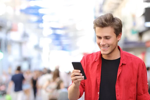 Uomo in rosso sms su un telefono cellulare — Foto Stock
