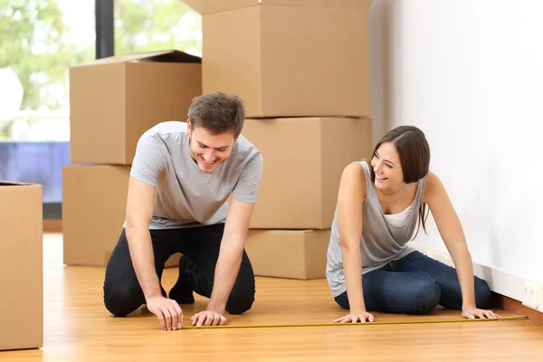 Couple moving house and measuring — Stock Photo, Image