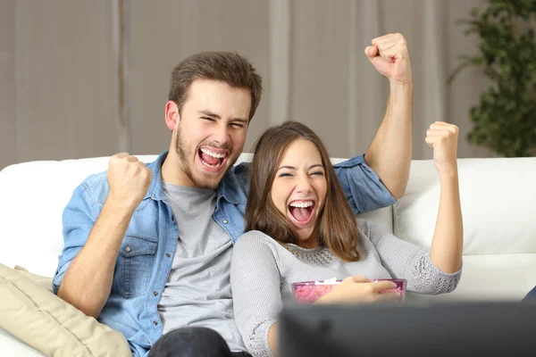 Pasangan euforik menonton tv di rumah — Stok Foto