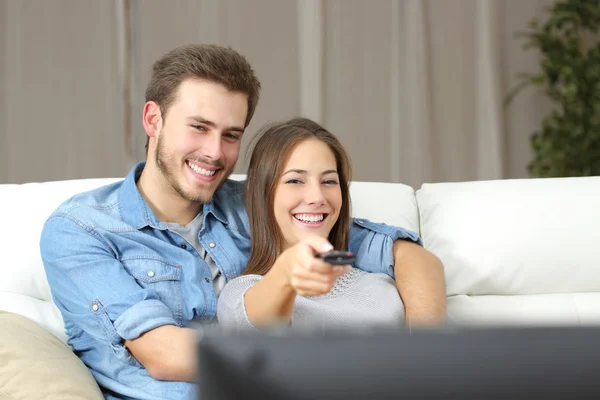 Casal feliz mudando de canal na tv — Fotografia de Stock