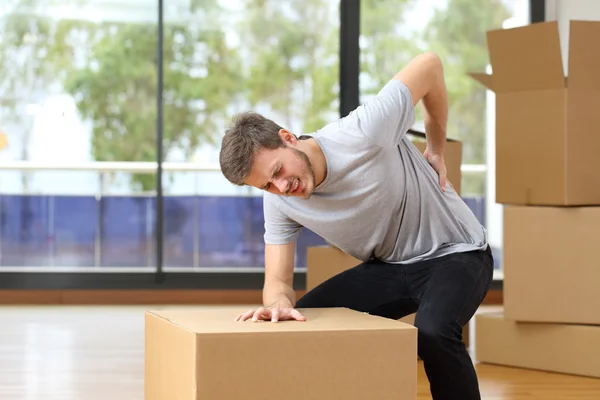 Homem sofrendo dor nas costas caixas móveis — Fotografia de Stock