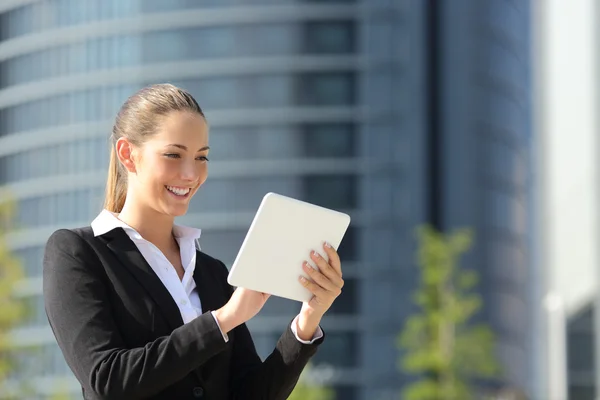 Business woman using a tablet in the street — Stock Photo, Image