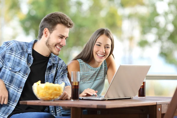 Casal assistindo mídia em um laptop ao ar livre — Fotografia de Stock