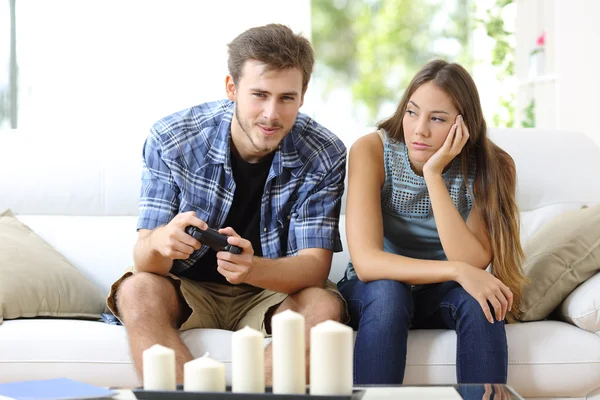 Hombre jugando videojuegos y novia aburrido al lado —  Fotos de Stock