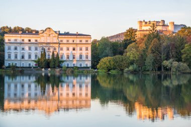 Leopoldskroner Weiher Gölü 'nde güzel günbatımı renkleri ve arka planda Leopoldskron Sarayı ve Hohensalzburg Kalesi - Salzburg, Avusturya 