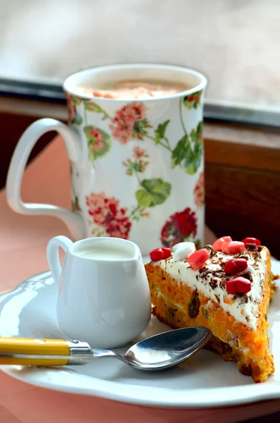 Pastel de zanahoria con caramelos de corazón, taza de café y leche en la crema que se sirve en el alféizar de la ventana —  Fotos de Stock