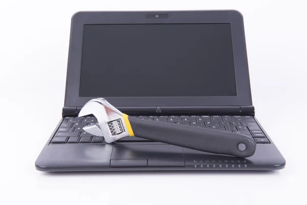 Siyah laptop bir İngiliz anahtarı ile — Stok fotoğraf