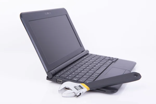 Siyah laptop bir İngiliz anahtarı ile — Stok fotoğraf