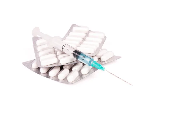 Embalagens de comprimidos brancos com seringa — Fotografia de Stock
