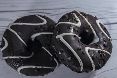 İki çikolatalı çörek beyaz bir masada izole edilmiş.