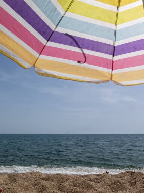 beach umbrella in the summer of spain with multi coloredin a blue sky