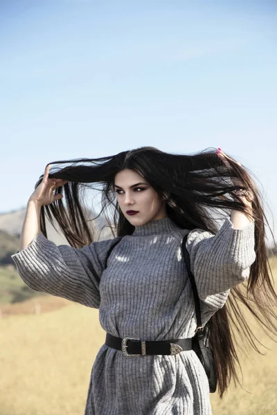 pretty brunette girl with very long hair over a blue sky