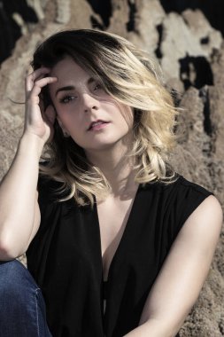 Açık havada yün kazak giyen genç bir kadının portresi.