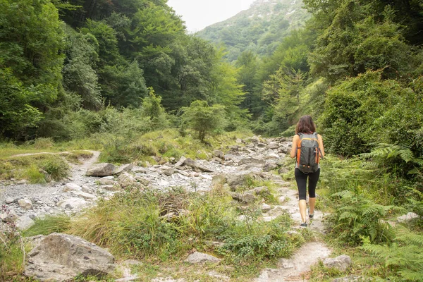 背中にリュックを背負ったまま山を歩く女 — ストック写真