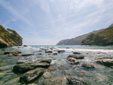 Costa Bravo 'daki kayalık koy güneşli bir yaz günü deniz ve mavi gökyüzü