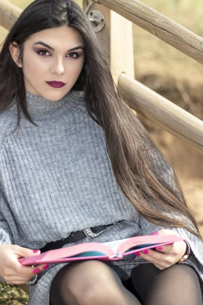 Morena Pelo Largo Sentada Una Escalera Con Libro Rosa Mirando — Foto de Stock