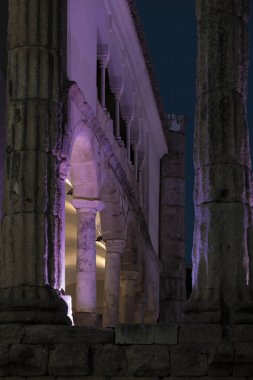 Merida 'da geceleri mor ışıkla aydınlatılmış sütunları ve kemerleri olan antik Roma harabeleri