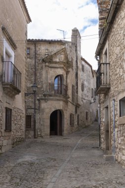 Taş binaların ve İspanyol köyünün geleneksel balkonlarının önünden geçen kaldırım taşı caddesi.