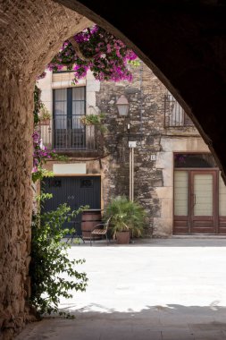 Ortaçağ taş mimarisi büyüleyici bir köy meydanına giden bir kemer yolu oluşturuyor.