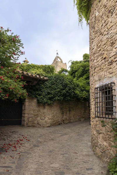 Taş binaların ve yemyeşil yaprakların arasında dolambaçlı, tarihi bir köy.