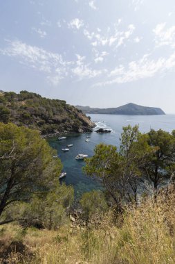 Berrak turkuaz sularda demirli kayalıklı bir körfez içeren huzurlu Akdeniz kıyıları
