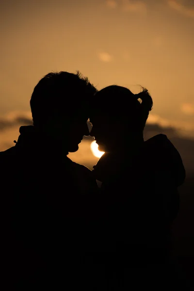Mladý pár před západem slunce — Stock fotografie