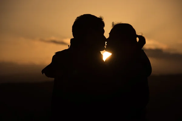 Young couple in front of sunset — Stock Photo, Image