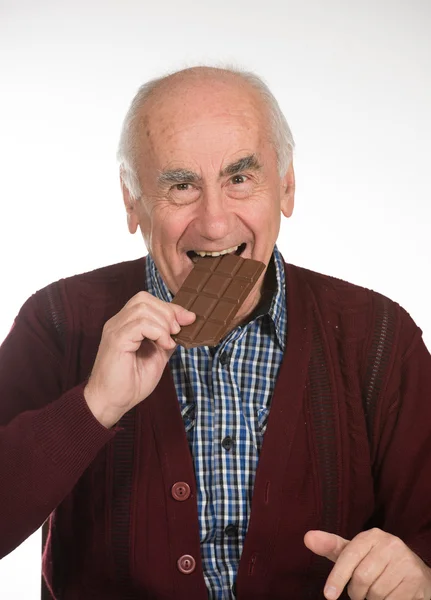 Oude man eten van chocolade — Stockfoto