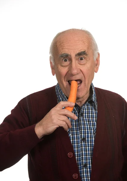 Starý muž jíst mrkev — Stock fotografie