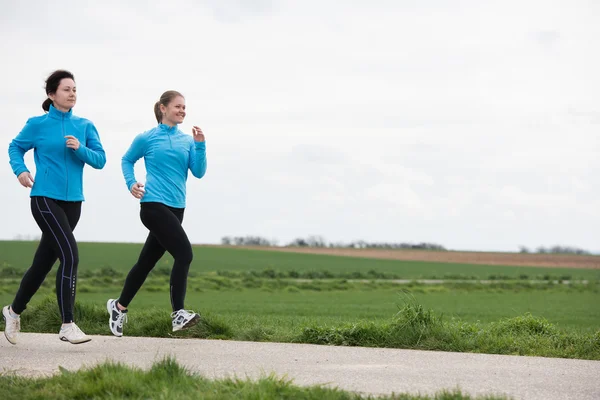 Twee vrouwen buitenshuis joggen — Stockfoto