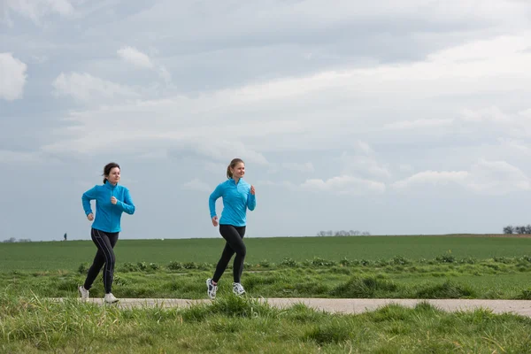 Dos mujeres corriendo al aire libre — Foto de Stock