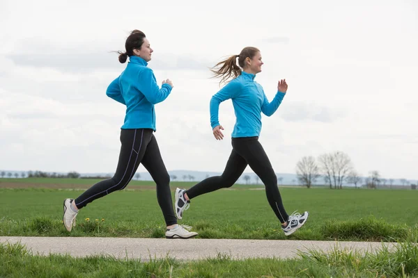 Dos mujeres corriendo al aire libre — Foto de Stock