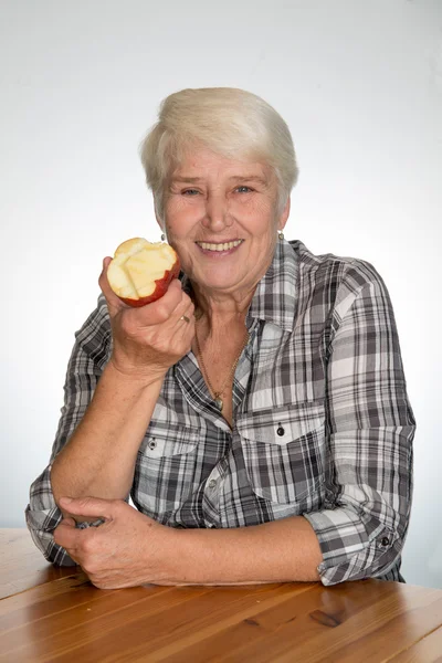 Vrouw die een appel eet — Stockfoto