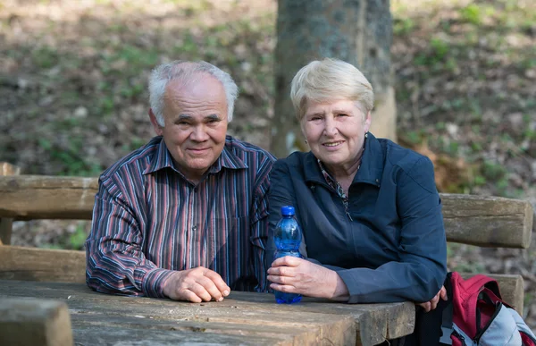 Older couple sitting on a bench — Stock Photo, Image