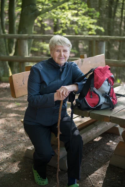 Senior vrouw zitten op een bankje — Stockfoto