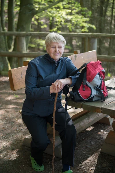 Seniorin sitzt auf einer Bank — Stockfoto