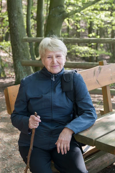 Starszy kobieta siedzi na ławce — Zdjęcie stockowe