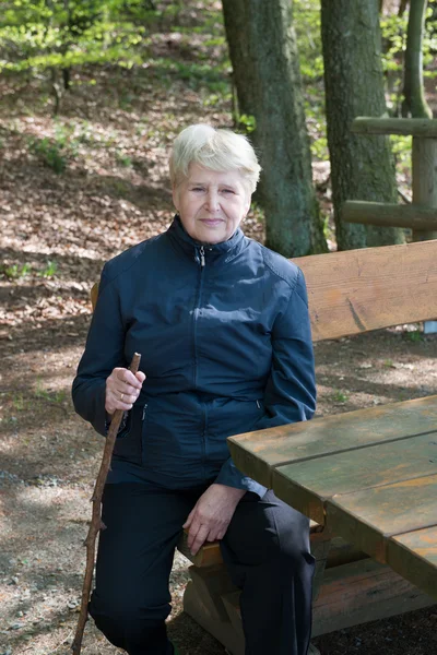 Femme âgée assise sur un banc — Photo