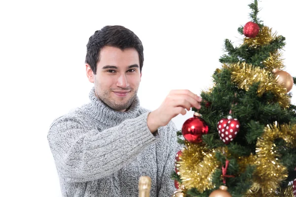 Young man decorating Christmas tree Royalty Free Stock Photos