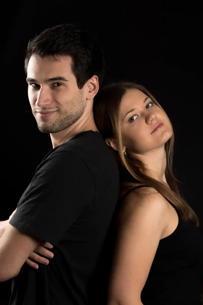 Young couple on black background — Stock Photo, Image