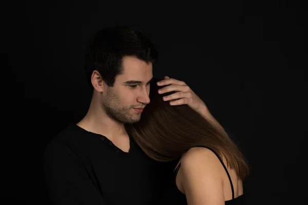 Young couple on black background — Stock Photo, Image