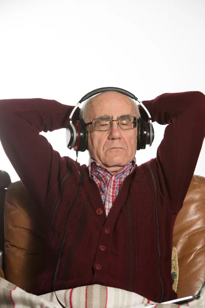 Oude man luistert muziek — Stockfoto