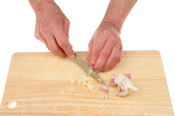 Mãos cortando alho — Fotografia de Stock