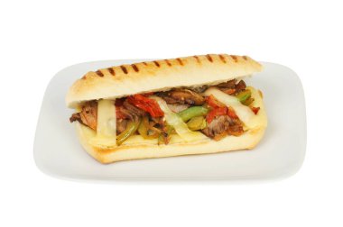 Sığır eti, soğan, biber, domates ve emmental peynir beyaz bir tabakta yalıtılmış.