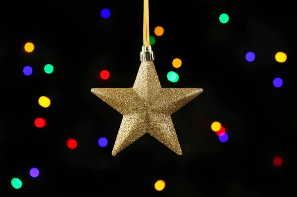 Gouden Glitter Kerstster Bauble Tegen Een Achtergrond Van Bokeh Kerstverlichting — Stockfoto