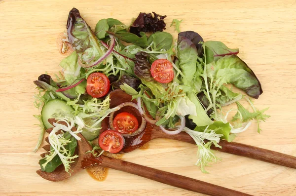 Salada em uma tigela com servidores de salada de madeira — Fotografia de Stock