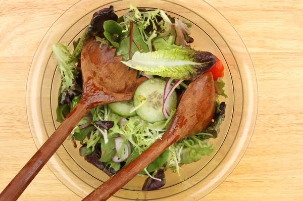 Salada em uma tigela com servidores de salada de madeira — Fotografia de Stock