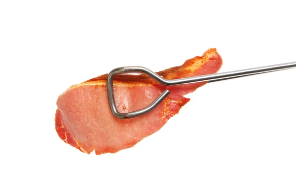 Bacon rasher in tongs — Stock Photo, Image