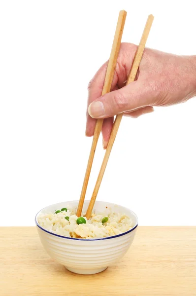 Hand holding chopsticks in rice — Stock Photo, Image